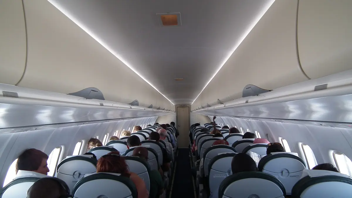 Airplane cabin with dimmed lighting and rows of seats