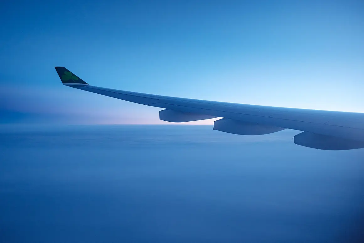 Airplane wing above the clouds in early morning light